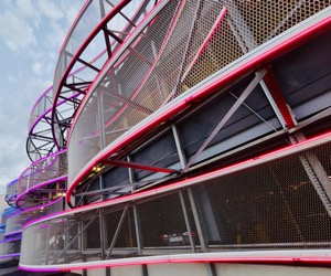 Magenta and yellow lines flowing across an industrial structure