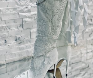 Étoile Blanche Crystal Lace Couture Boots — A side view of the knee-high silhouette, the lace and the trailing back ribbons.